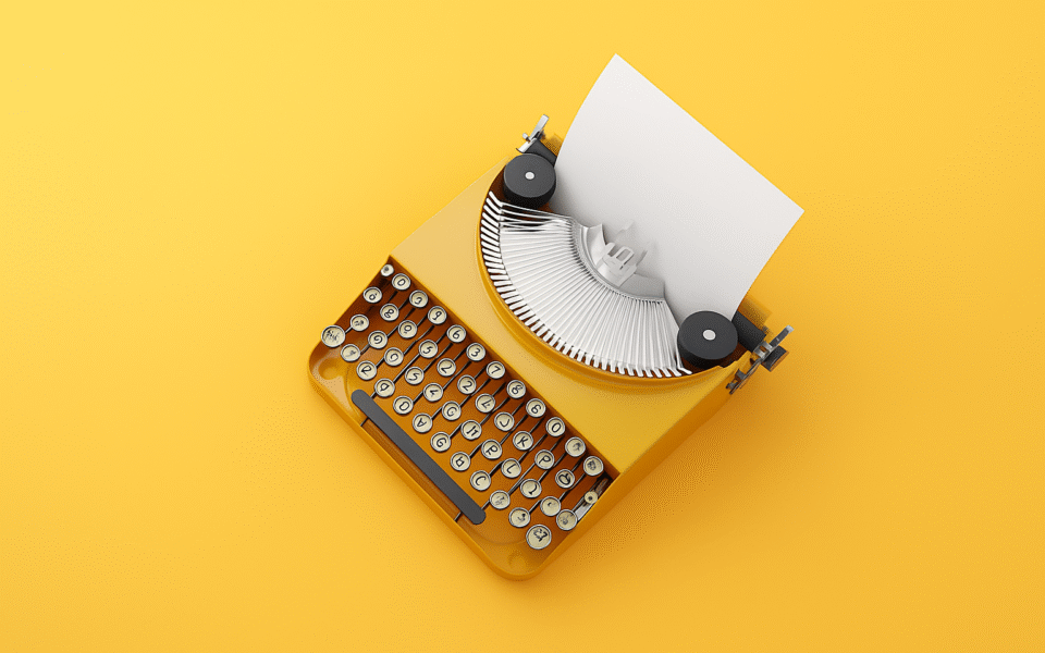 Na jednolitym, intensywnie żółtym tle widoczna jest klasyczna, żółta maszyna do pisania z włożoną czystą kartką papieru.
